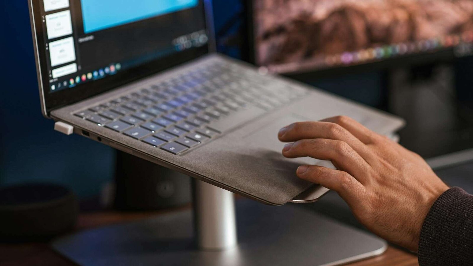 crop faceless man using laptop on stand