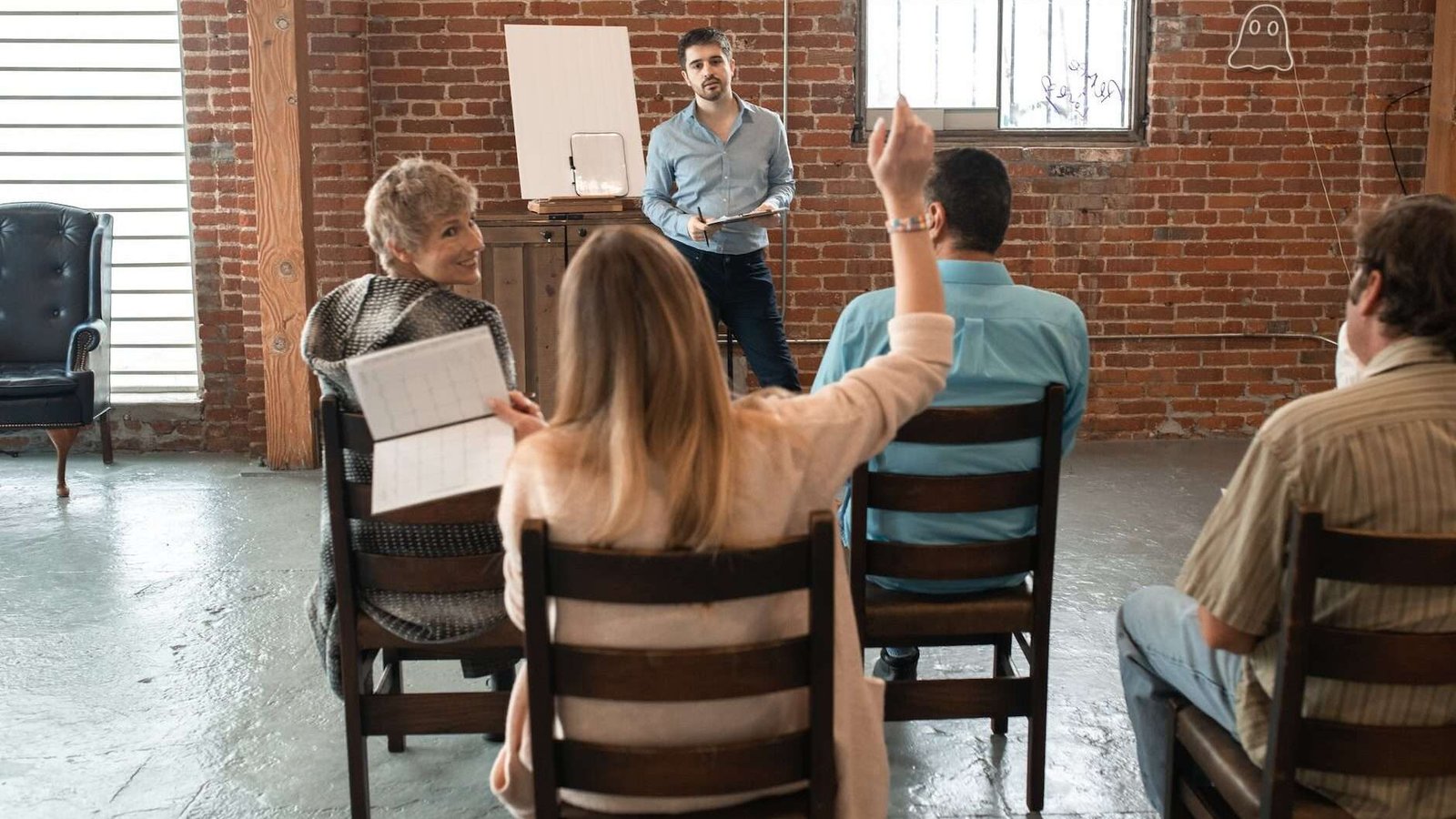 woman sitting at the back raising her hand