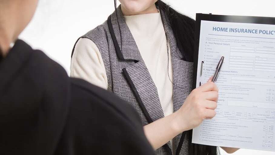 a woman showing the document on the clipboard to a person standing in front of her