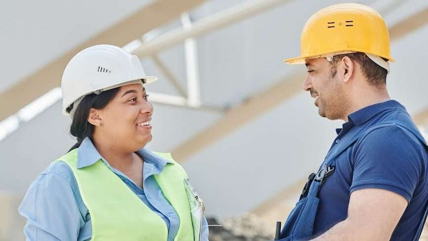 a man and woman wearing hardhats while having conversation