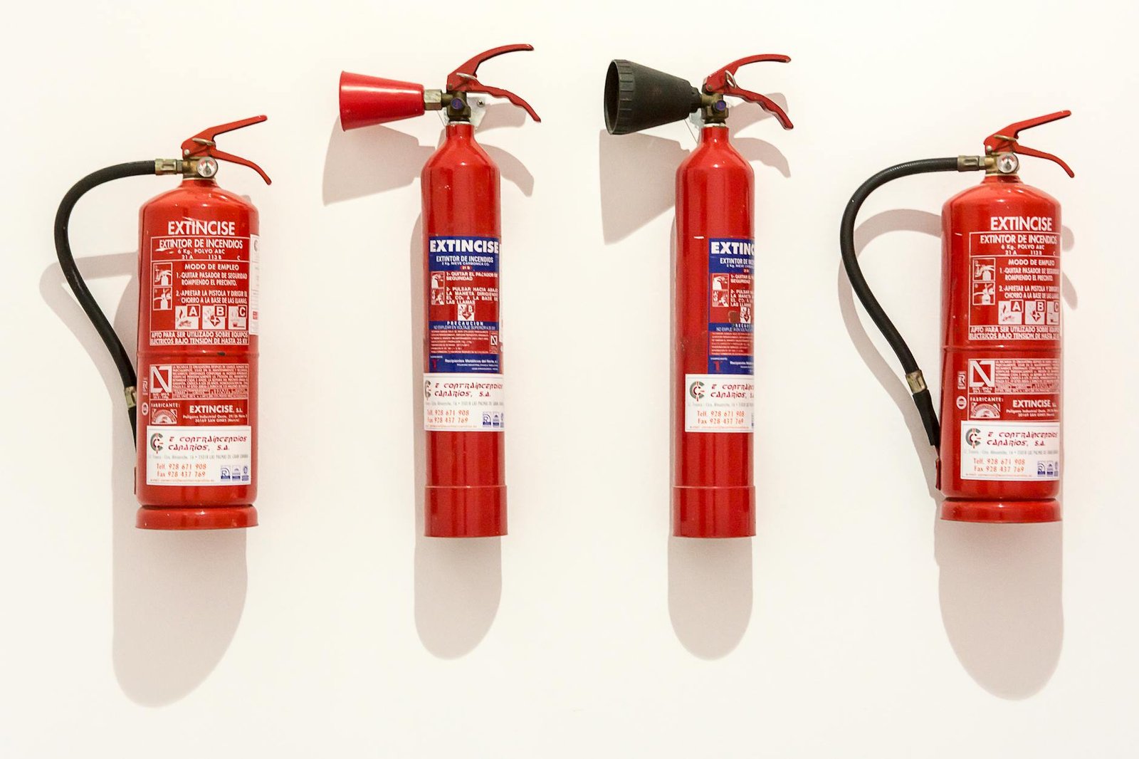 assorted fire extinguishers on white surface