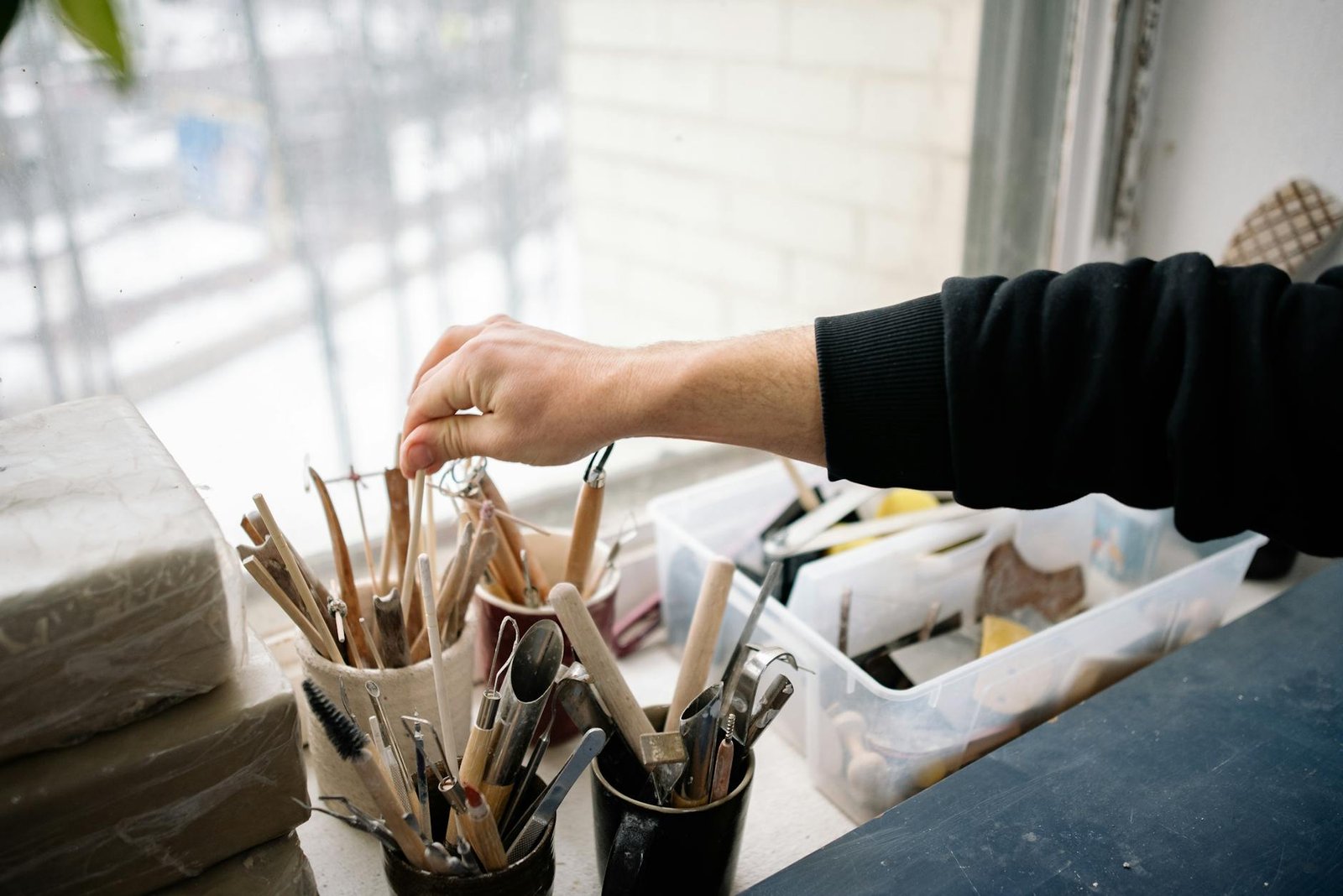 close up of a person choosing a tool in an art studio